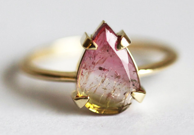 A watermelon tourmaline ring featuring what look like suspended magical particles.