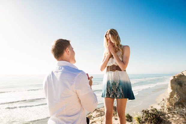 Young man proposing to girlfriend by sea, Torrey Pines, San Diego, California, USA