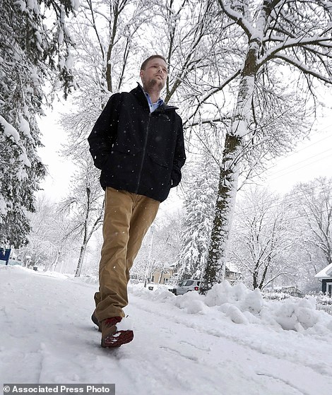 In this Jan. 25, 2017, photo, face transplant recipient Andy Sandness walks to the Saint Marys Hospital campus at Mayo Clinic in Rochester, Min. Sandness can pinpoint the day he looked normal. About three months after the procedure, he was in an elevator with a little boy who glanced at him, then turned to his mother without appearing scared or saying anything. "I knew then," he says, "that the surgery was a success." (AP Photo/Charlie Neibergall)