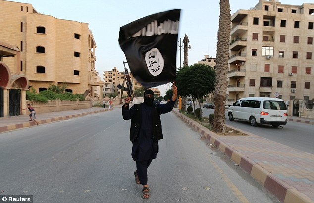 A member of ISIS waves the terror group's flag and a gun in the air as he walks down the street