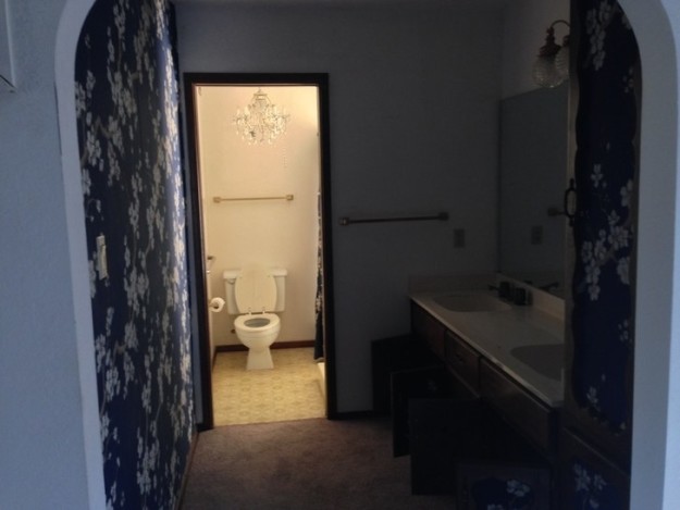 This dark and outdated bathroom with felt (!) wallpaper...