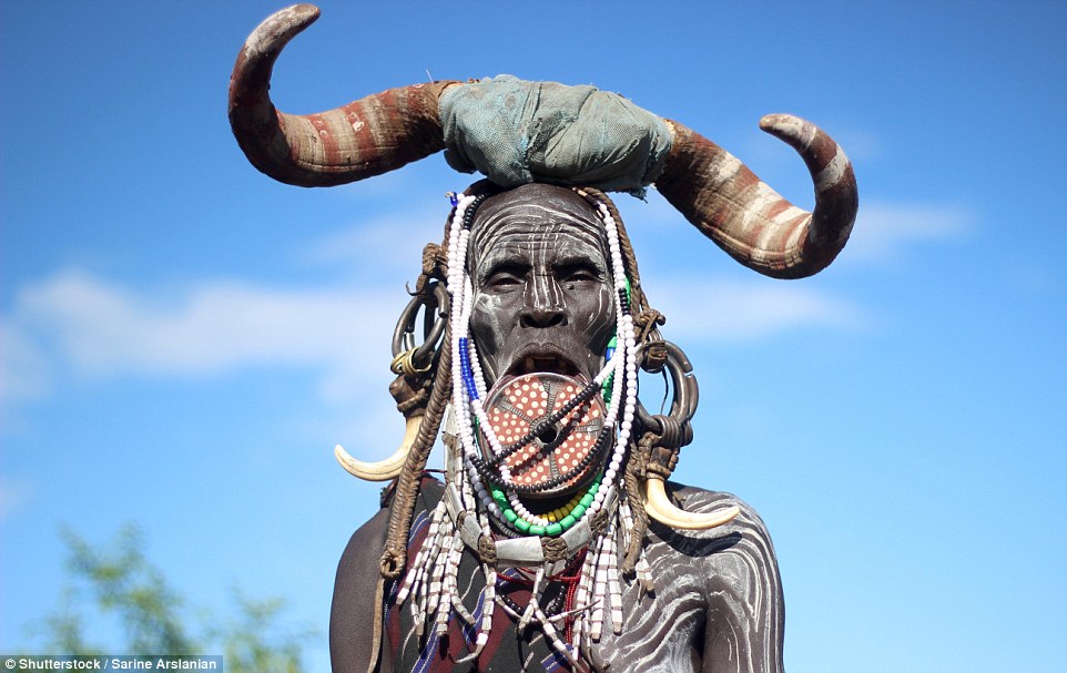 Another woman from the Mursi tribe wearing a lip plate and a set of cow horns atop her head. The more decorative her appearance, the higher her standing is