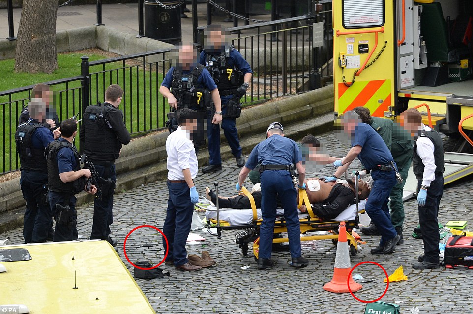 The suspected terrorist, pictured on a stretcher, is also dead, along with three pedestrians killed when the attacker drove a 4x4 across Westminster Bridge, ploughing down and seriously injuring at least 20. He had two knives (ringed)