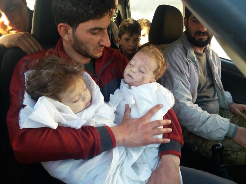 A devastated father has been pictured cradling the bodies of his dead twins after they were killed during the chemical attack in Khan Sheikhoun, in the rebel-held central province of Idlib, Syria