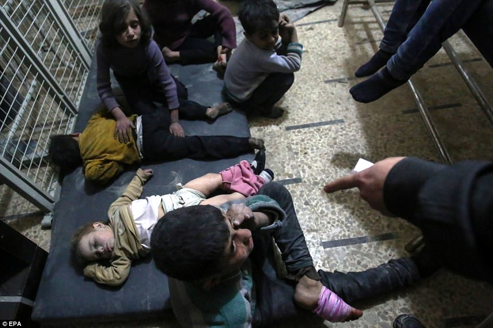 More than 30 people were injured and one was killed in an attack in rebel-held Douma on Tuesday. Pictured above, children in Douba wait for treatment following the attack