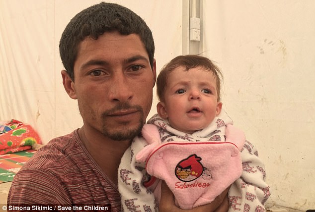 Salar, 34, pictured with daughter Marwa, who was born five months ago at the family's home in the Iraqi city, where ISIS is using civilians as human shields