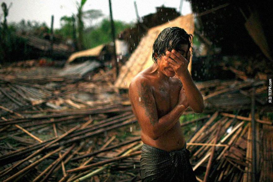 29歲的 Hhaing The Yu 的家園被摧毀後忍不住悲傷捂著臉哭泣。2008年5月的時候，一個超大的龍捲氣旋襲擊了緬甸仰光，奪走了百萬人的家園和十萬條人命。