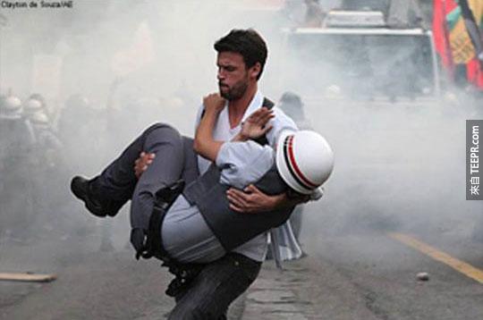 巴西示威者把一名受傷的員警救出危險地區 (聖保羅，巴西 2012)。