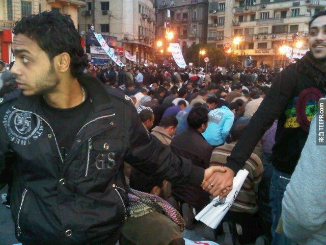 基督徒在穆斯林教徒禱告的時候守護他們 (開羅，埃及 2011)。