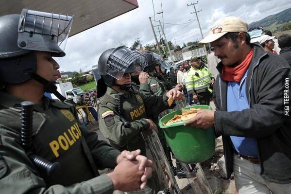 示威者跟警察分享餅乾 (哥倫比亞 2013)。