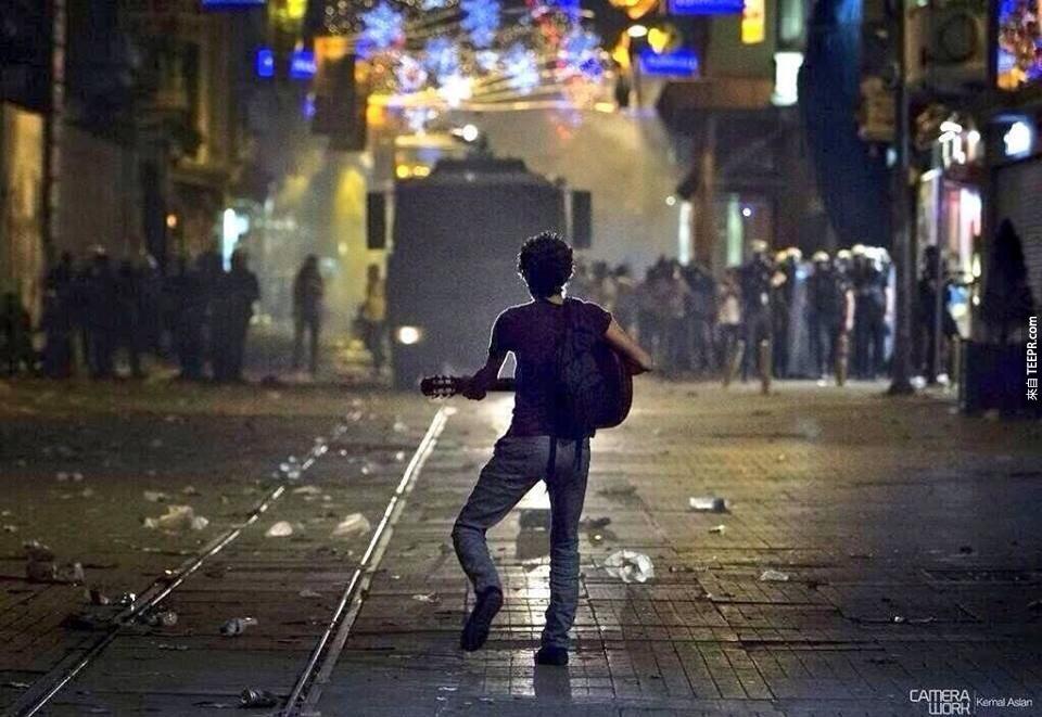 一名土耳其的示威著彈奏吉他給警察聽 (土耳其 2011)。