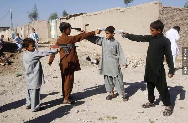 阿富汗宰牲节（Eid al-Adha）的第一天，小男孩们拿着玩具枪指著对方。 