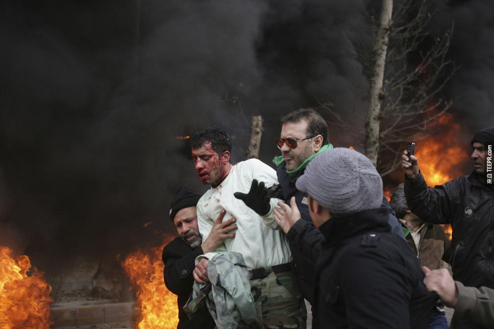 一些平民出現救出一名被示威者打傷的員警 (德黑蘭，伊朗 2009)。