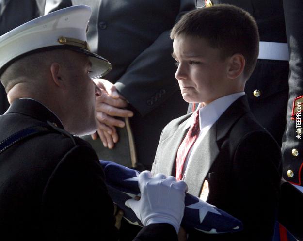 11. 8歲的Christian Golczynski忍著淚水替已在伊拉克不幸過世父親（Marc Golczynski）接受軍人榮譽的旗子。