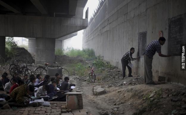 12. 印度的老師在破爛的街邊堅持教育無家可歸的孩子。