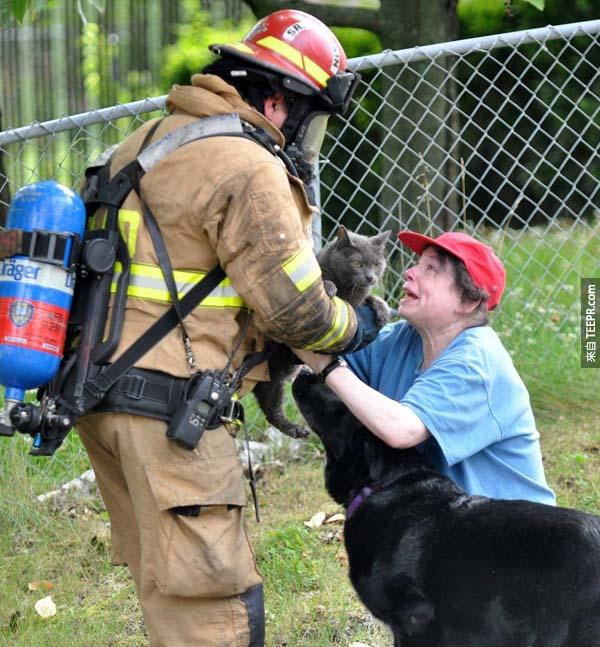 18.) 一位消防员冒着危险，拯救这位妇人的爱猫。