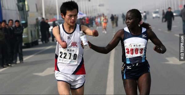 31.) 一位世界級的馬拉松跑者慢下腳步，幫助一位身障人士喝水。
