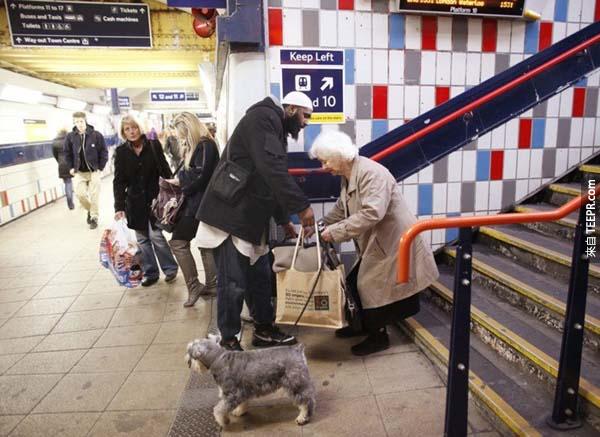 7.) 一位男子停下赶火车的脚步，帮助一位正在努力处理包包的老婆婆。
