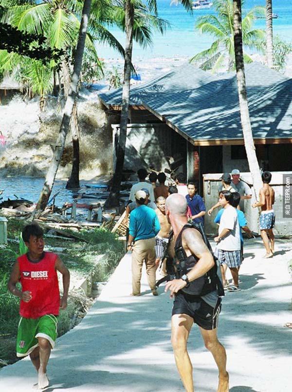 13.)2004年海啸袭击泰国，游客与当地人在神色仓皇地逃跑。