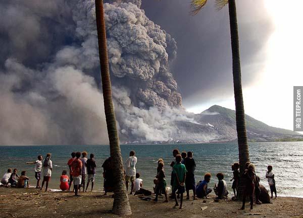 17.) 安全撤退的人们，在岸边看着新畿内亚塔乌鲁火山喷发。