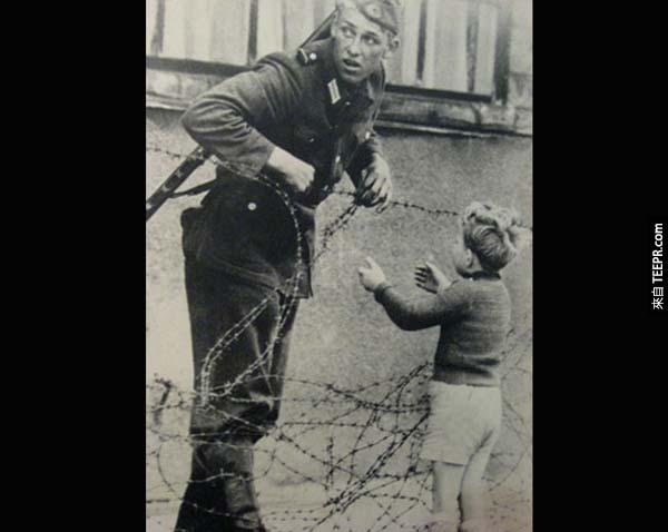 4.) 柏林圍牆的拯救: 這位來自東德的軍人知道他不應該讓這名孩童跨越柏林圍牆，但孩童與他的父母走散了。這位士兵還是把鐵絲撩起來，讓孩童過去，但他非常警戒，四處觀看是否有人看見。(那拍照的人呢？)