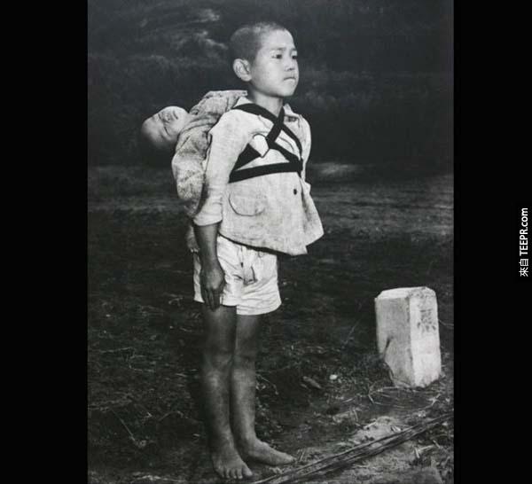 10.) 長崎市(Nagasaki)兄弟檔: 這張照片攝於空襲發生後不久。照片中年紀較小的孩童已經死了，年紀較大的這位是他的哥哥。他正帶著他的弟弟前往火葬場，可以看見他的眼神是如此地堅強，忍著快要低下來得淚水。即便他已經失去全世界，他仍要光榮地送弟弟最後一程。