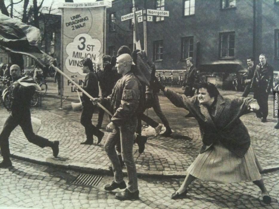 一位瑞士的女子正在用手提包打一位新纳粹份子，据报导，这名女子是集中营的幸存者。(1985年)