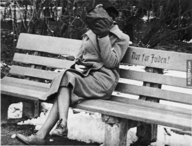 4.) 一位猶太女士在奧地利的長椅上坐著，上面寫著「猶太人區」，1938。 