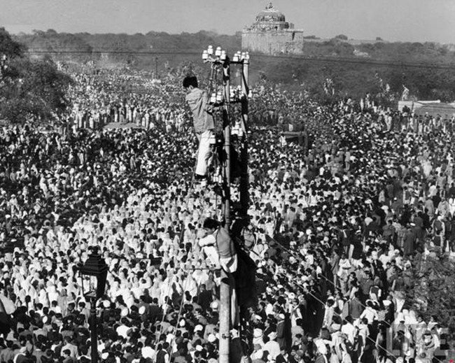 悼念者爬上電線杆觀看甘地(Gandhi)喪禮的過程。[1948]