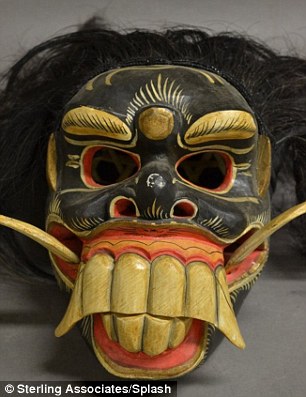 Chilling: The kit, which also contains intricately carved wooden stakes (left), has been given a starting bid of $5,000 at an auction in Closter, New Jersey. Right, another item in the sale, a Japanese demon mask