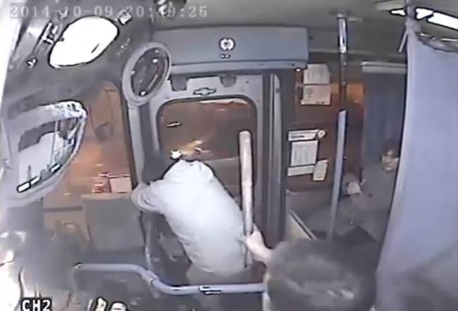 The bus driving pulls out a baton in order to intimidate the mugger and to keep him from escaping.