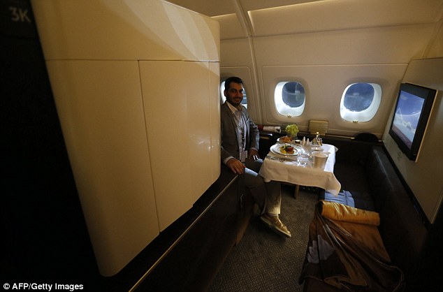 A journalist sits in one of the first class suites on Etihad Airways' Boeing B787 Dreamliner