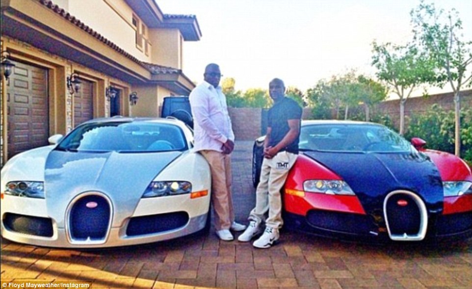 Mayweather (right) shows off two of his Bugattis, which he had before fighting Marcos Maidana in May last year 