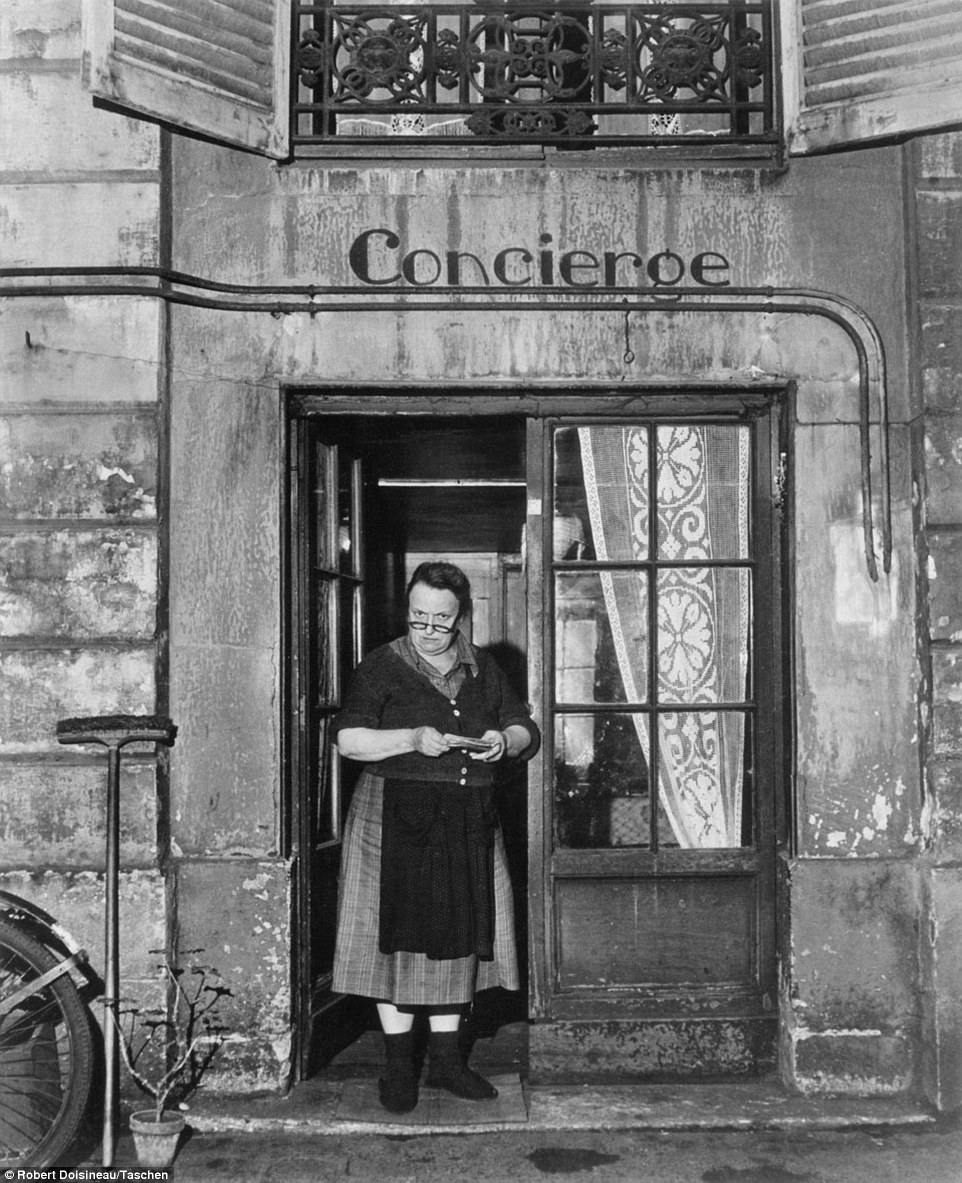Stern: A woman looks out from the doorway of her home, peering sternly at Doisneau's camera 