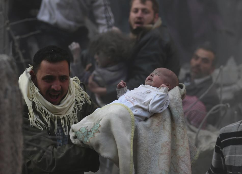 1. 在據稱為敘利亞總統指揮的一場空襲當中，一個男人抱著活下來的小嬰兒。