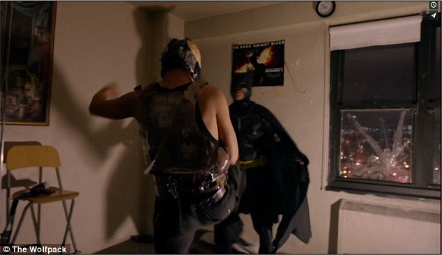 Two of the brothers (dressed as Batman and Bane from The Dark Knight Rises) re-enact a scene from the movie in their Manhattan home 