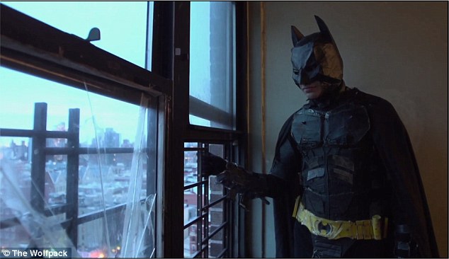 The siblings were given the outlet of movies in their confined lives - leading to elaborate reconstructions. In this picture, one brother stares from the family's apartment in his Batman costume, made entirely out of ceral boxes and yoga mats