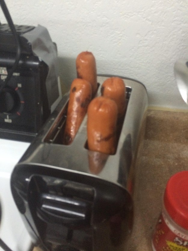 Putting hot dogs in a toaster.