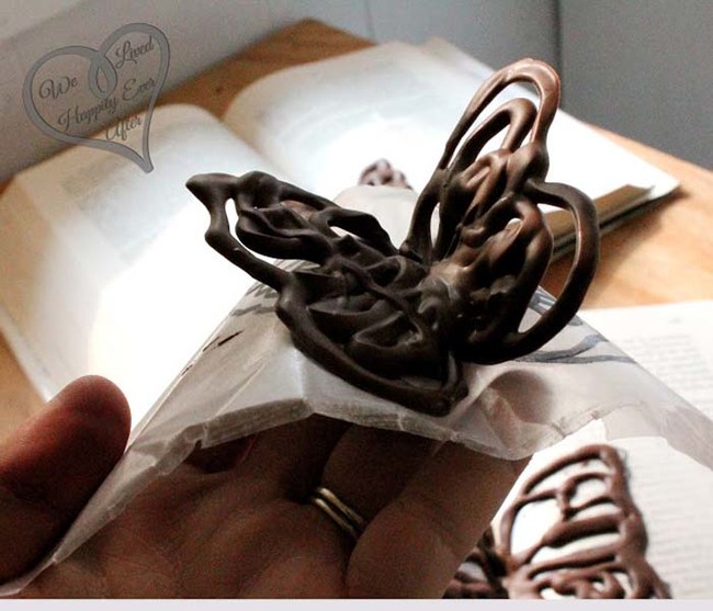 Slip the paper out of the book and gently peel the chocolate butterfly away.