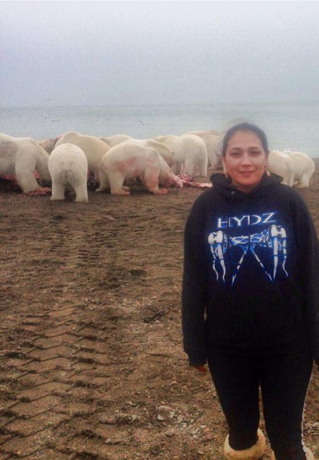 這位女網友因為身旁有一群拿著來福槍隨時待命著的朋友，於是才敢放膽和這群嗜血的北極熊合照。