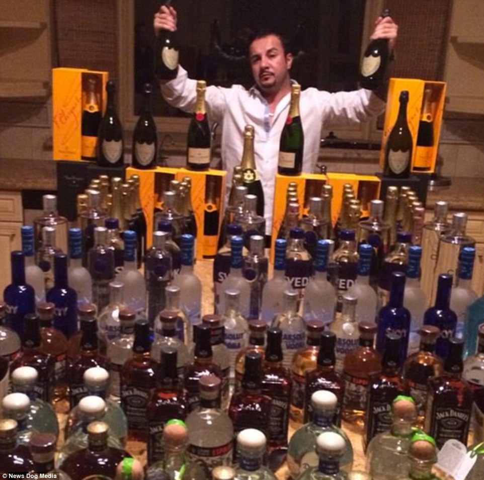 Bottoms up: Toutouni poses in front of dozens of bottles of spirit and champagne in this photo uploaded to his account