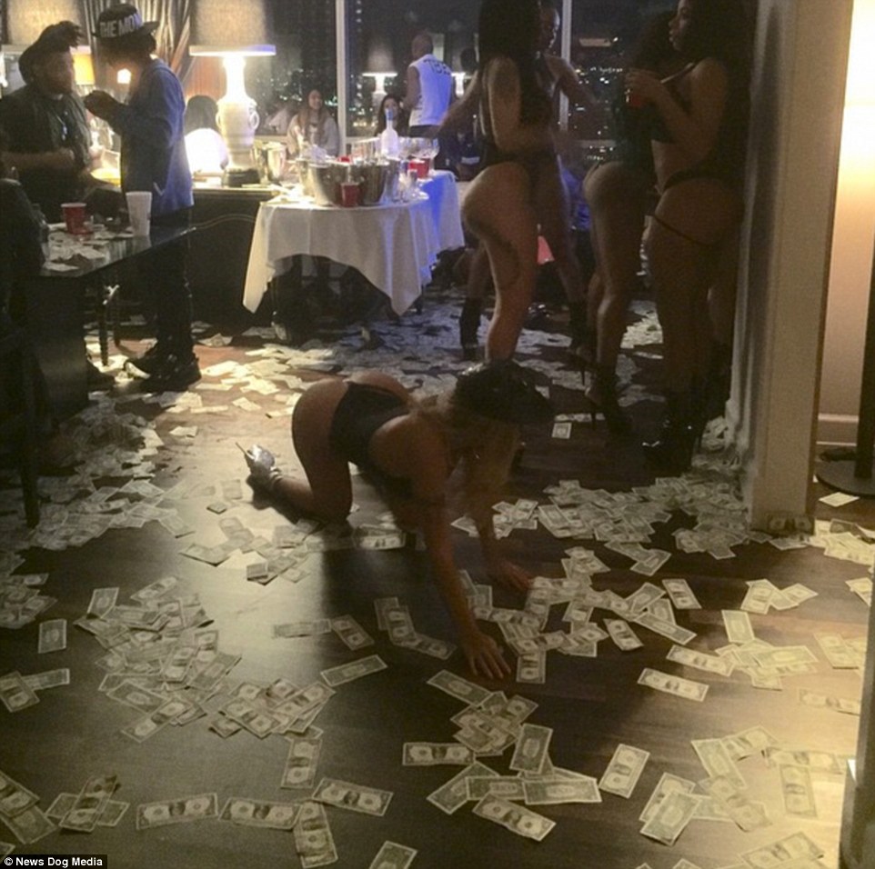 Wild debauchery: One photo uploaded by the billionaire shows scantily-clad women at a party with cash scattered across the floor