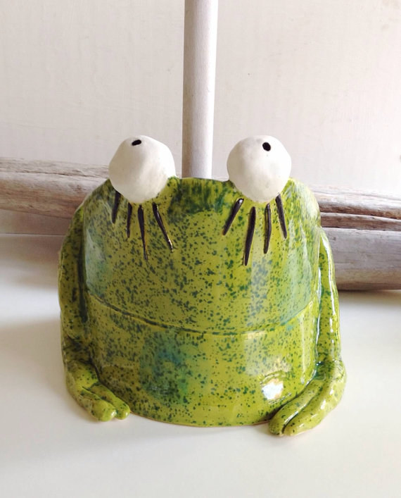 A ceramic frog plunger cover.