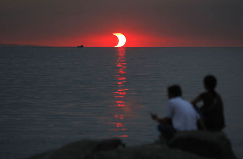 An eclipse and a sunset happening at the same time.