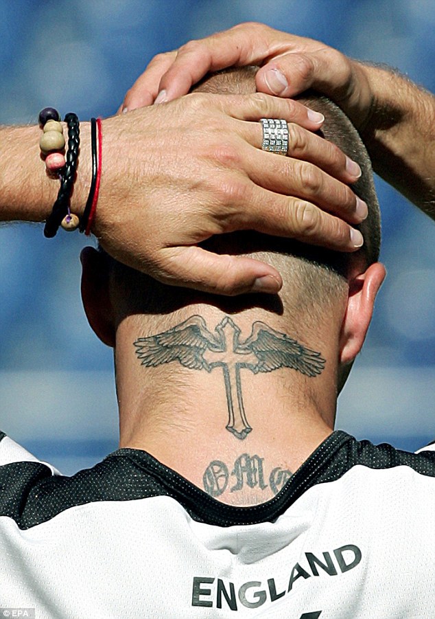 David shows off a crucifix tattoo on the back of his neck in2004