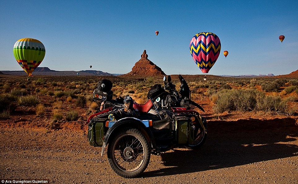 Canine adventurer: Spirit poses in his sidecar as hot air balloons land behind him, in Utah's stunning Valley of the Gods