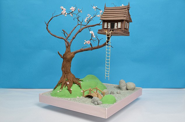 Up in the air: An idyllic tree house sits on branches made of wires covered in chocolate in a garden complete with sugar paste blossom and sugar ladder 