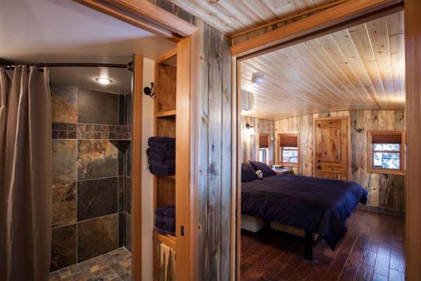 A family can keep cozy in this renovated caboose that has a fully equipped kitchen, two sets of bunk beds, and a queen-sized bed with a gas fireplace in the master bedroom.