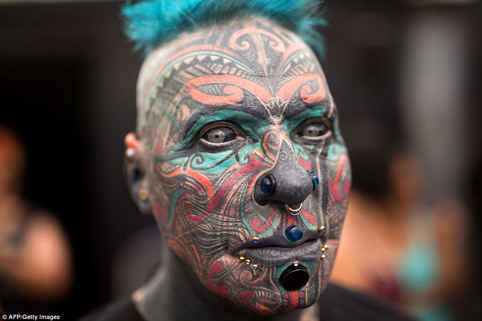 Weird and wonderful: As well as the intricate tattoos across his face, 'Magneto' is also covered with piercings, including flesh plugs in his nose, ears and lower lip