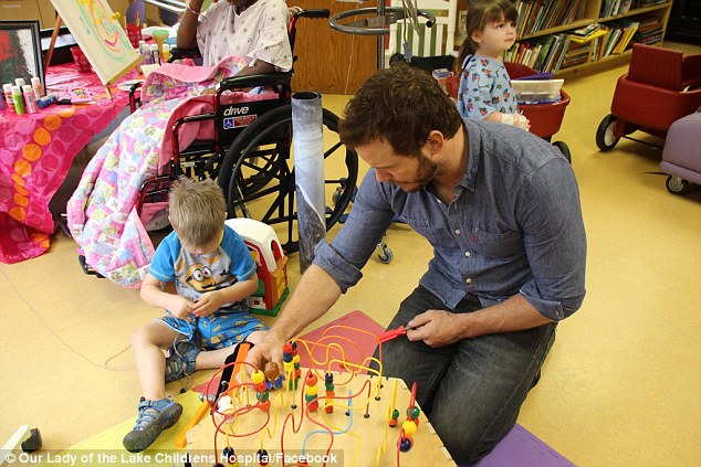 Hands on: Chris also joined in playtime and was taught a thing or two in return by some of the the patients 